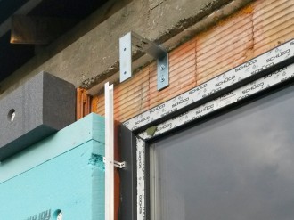 Hliníkové stavební pouzdro je uchyceno do okenního rámu, Nosná ocelová konzole o síle 8mm slouží také pro uchycení čelní heraklitové nebo fermacelové desky.