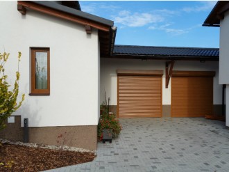 Odstín garážových rolovacích vrat přizpůsoben barvě okenních rámů.