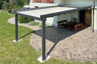 Pergola se stahovací střechou kotvená ke stěně.