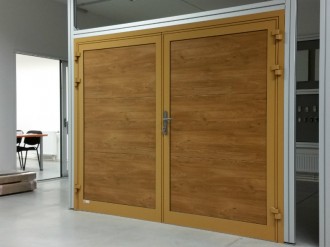 Vzorek garážových vrat dvoukřídlých zateplených. Hliníkové lakované rámy, izolační PUR panel v imitaci dřeva.