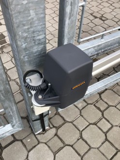 Detail uchycení těla pohonu křídlové brány ke sloupku.