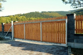 Samonosná brána s dřevěnou výplní, nesená posuvná do strany. Pohon Hormann LineaMatic.
