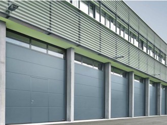 Sekční průmyslová vrata Hormann s integrovanými dveřmi a řadou prosklení. Průmyslové vrata.