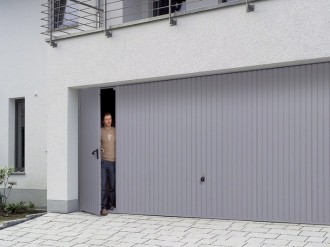 Výklopná garážová vrata s integrovanými dveřmi.